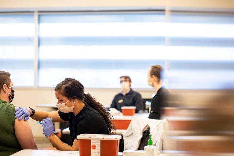 health sciences student administers vaccine