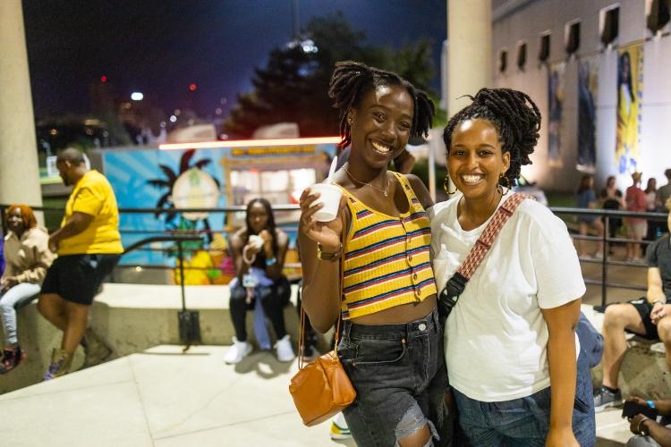 Students smile in front of an ice cream truck at Late Night with the Greeks