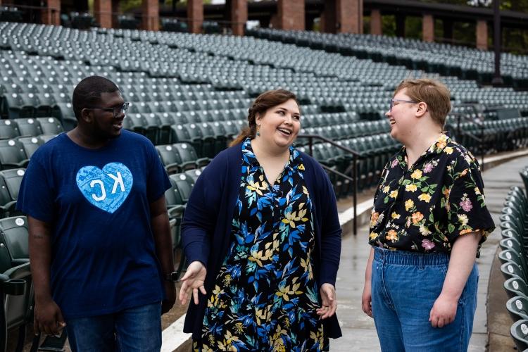 Roslinde Rivera smiles and walks through the Starlight seating bowl with two Starlight employees