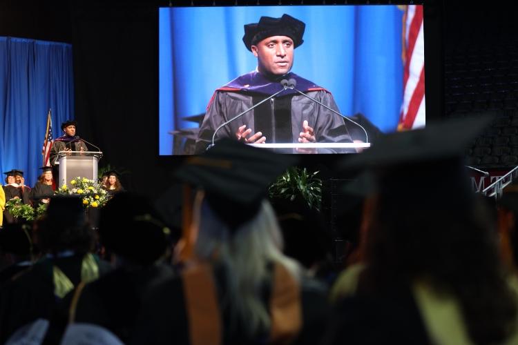 Mayor Quinton Lucas stands at the podium in regalia