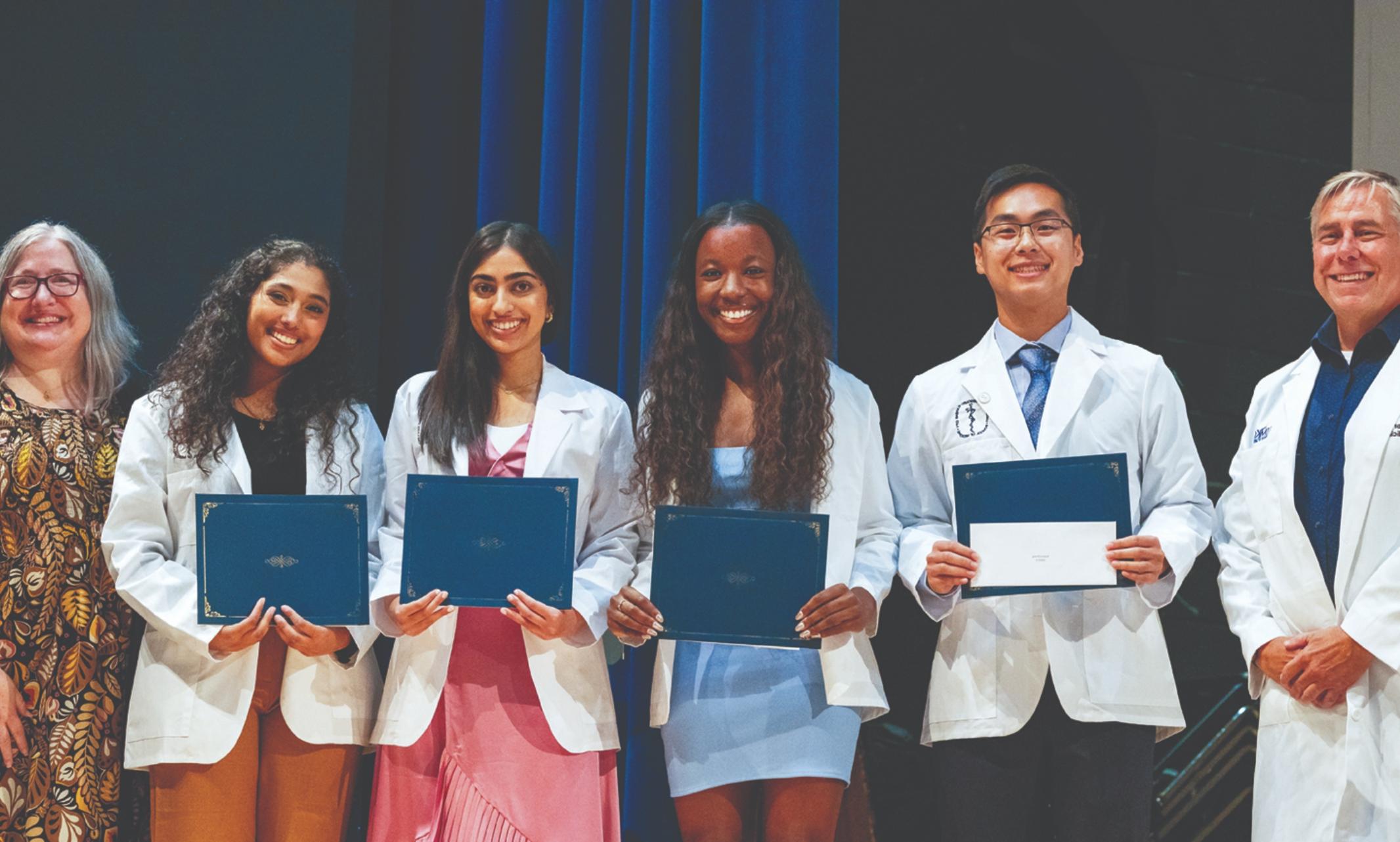 Students dressed in white coats